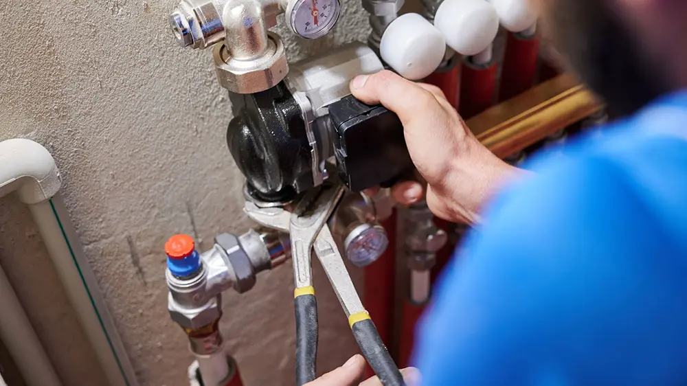 A plumbing professional is working on a water heater.